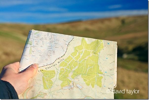 Walker holding an Ordnance Survey map of the Cheviots hills, Northumberland National Park, England. OS REF: NT 883143, hiking safety, hiking essentials, hiking safety tips, what to wear hiking, navigational aids, landmarks, Warm, cold, weather, climate, snow, heat, exhastion