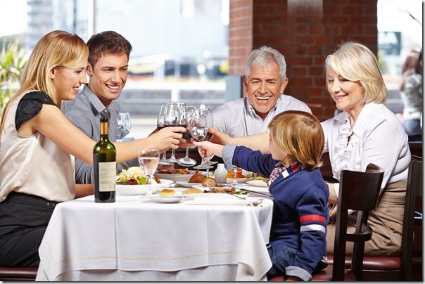 Familie im Restaurant prostet sich zu