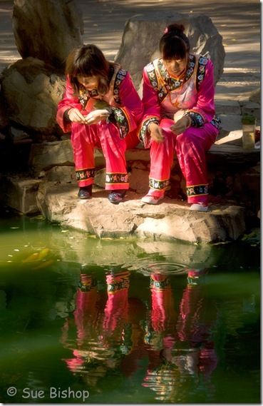 girls feeding fish at prince gongs palace