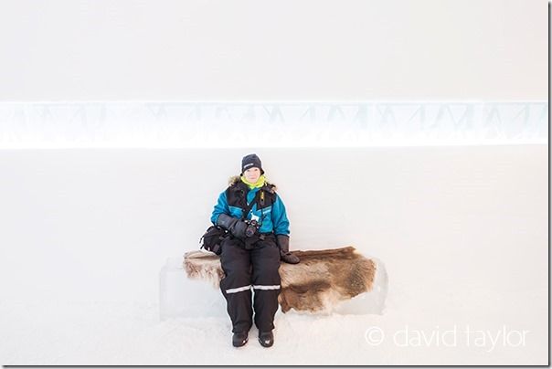 Female dressed in warm winter clothes sat in the reception of the Ice Hotel at Kiruna, the Arctic Circle region of Sweden