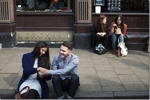 A romantic couple sit and hold hands and talk outside the Cat and Mutton pub in Broadway Market, Hackney, East London