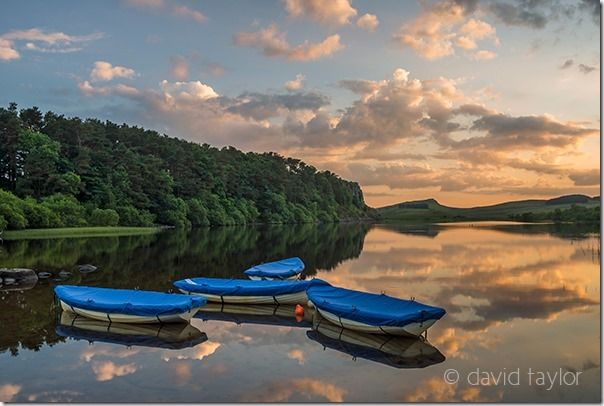 Boats on Crag Lough in Hadrian's Wall Country on a summer's evening, Northumberland, England