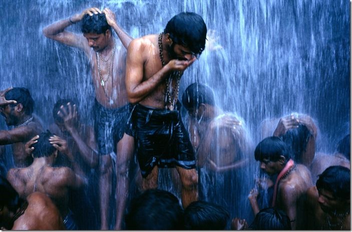 Followers of the Shiva sect of Hinduism (known as Shaivites or Shaivas) ritually bathe at a Hindu Bathing festival at Courtalam waterfall, Tamil Nadu, India. The town is dedicated to Lord Thirukutralanathar (Lord Siva). The Chittar River flows through the town into the main falls called the Peraruvi.